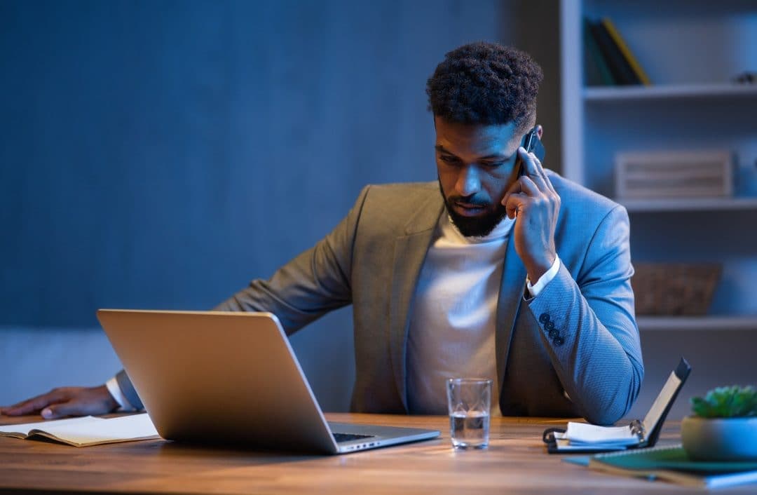 Professionista al telefono in ufficio la sera